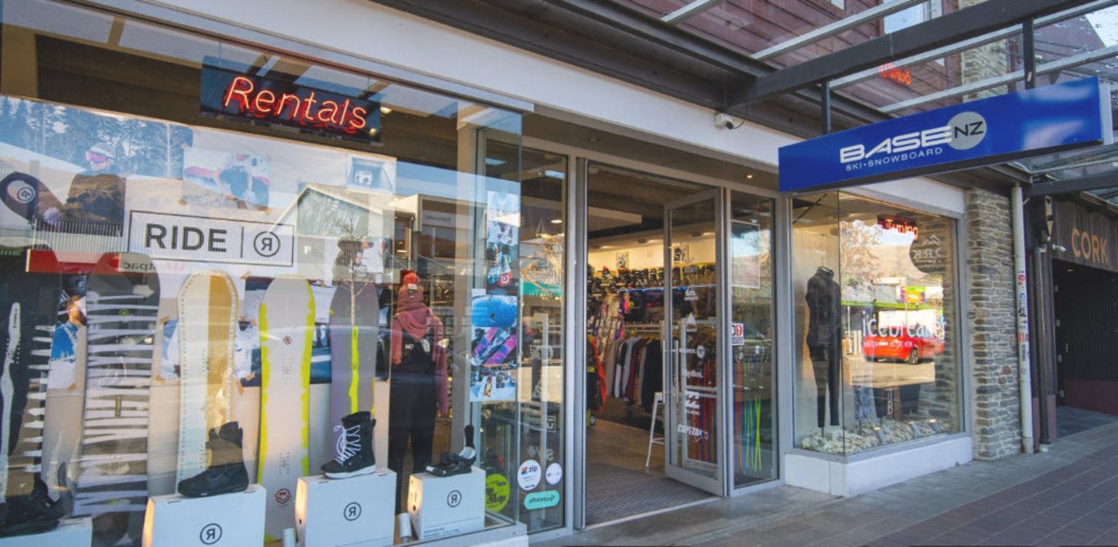 Storefront with 'Rental' sign and various items displayed through glass windows.